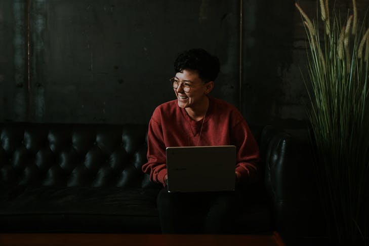 girl sitting on couch with laptop